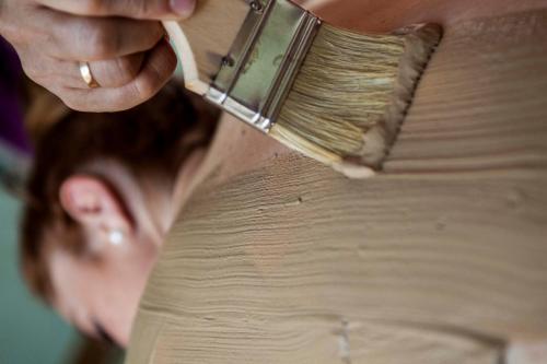 a woman applying paint to her shoulder with a brush at Hotel Balneario de Graena in Graena