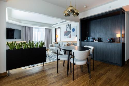 a dining room and living room with a table and chairs at Crowne Plaza Belgrade by IHG in Belgrade