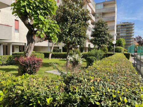 a garden with bushes and trees and a building at Casa Mia Lido Adriano III in Lido Adriano