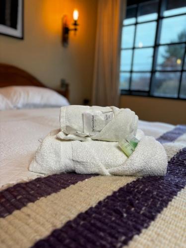 a pile of towels sitting on top of a bed at Hotel Boutique WenuPillan in Villarrica