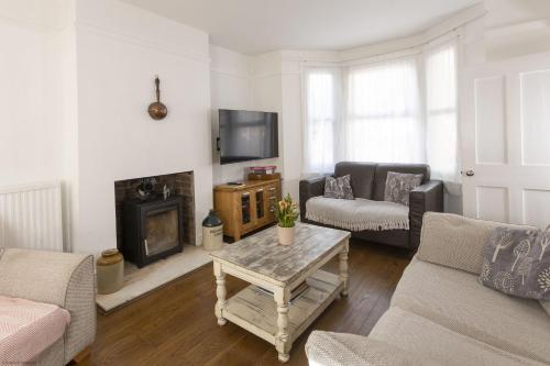 a living room with a couch and a fireplace at Orchard Cottage in Oxford