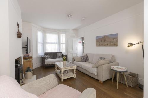a living room with two couches and a table at Orchard Cottage in Oxford