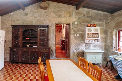 a dining room with a table and a cabinet at Casa de Requeixo in Póvoa de Lanhoso