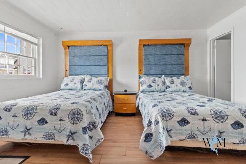 a bedroom with two beds and two windows at 2 Bed1 Bath on the Boardwalk by the Inlet in Ocean City