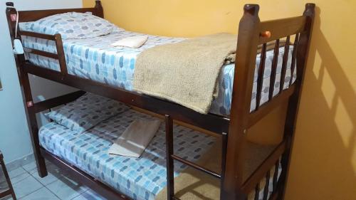 a wooden bunk bed with a blue and white bedspread at Trem Bão de Dormir in Recife