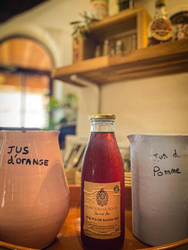 una bottiglia di salsa appoggiata su un tavolo con due contenitori di Château le Bouïs a Gruissan