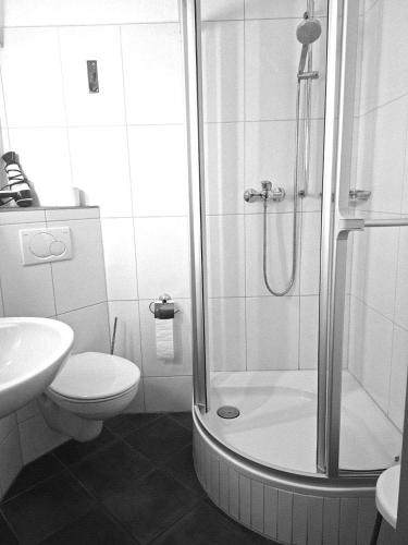 a bathroom with a shower and a toilet and a sink at City Hotel in Böblingen
