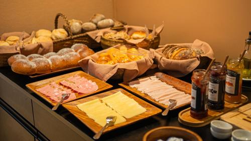 a table with cheese and other foods on it at Hotel Margarida Da Praça in Viana do Castelo