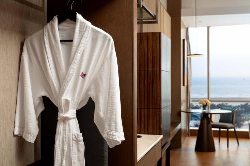 a white robe hanging on a wall in a hotel room at Crowne Plaza Beihai Silver Beach by IHG in Beihai