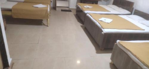 a room with several beds in a room at Kathiyawadi Resort park view matheran in Matheran