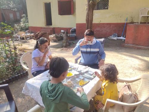 a group of people sitting around a table eating at Kathiyawadi Resort park view matheran in Matheran