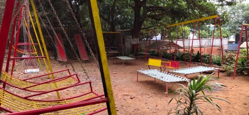a playground with red and yellow chairs and tables at Kathiyawadi Resort park view matheran in Matheran