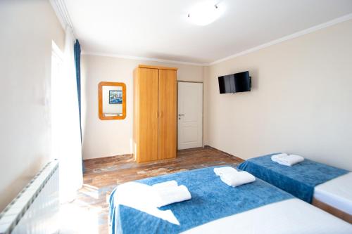 a room with two beds and a television at ACIKA apartments in Rafailovici