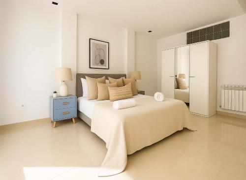 a white bedroom with a large bed and a mirror at Magnifique appartement à Kouba in Kouba