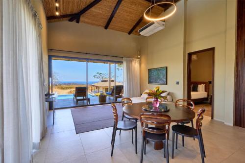 a dining room with a table and chairs and a bedroom at TreeCasa Hotel & Resort Nicaragua in San Juan del Sur