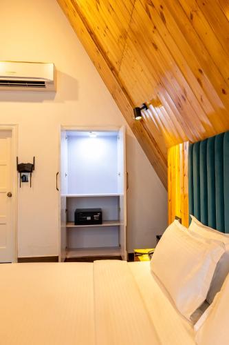 a bedroom with a bed and a wooden ceiling at Patio Farms by Saltstayz in Farrukhnagar