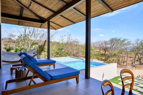 a patio with chairs and a swimming pool at TreeCasa Hotel & Resort Nicaragua in San Juan del Sur