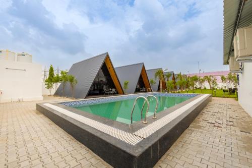 a swimming pool in the middle of a building at Patio Farms by Saltstayz in Farrukhnagar