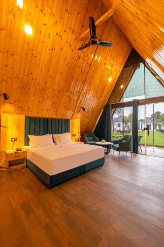 a bedroom with a bed and a wooden ceiling at Patio Farms by Saltstayz in Farrukhnagar