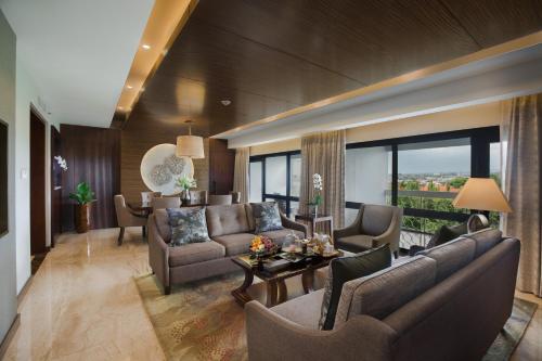 a living room with a couch and a table at Royal Ambarrukmo Yogyakarta in Yogyakarta