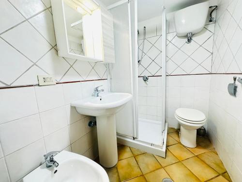 a white bathroom with a sink and a toilet at Dragonara in Ponza