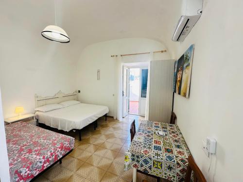 a room with two beds and a table in it at Dragonara in Ponza