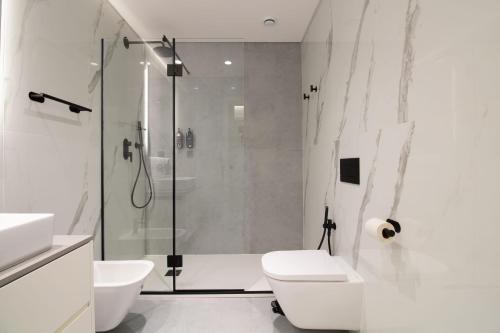 a white bathroom with a shower and a toilet at HILCROWN 39 Studios by LovelyStay in Vila Nova de Gaia