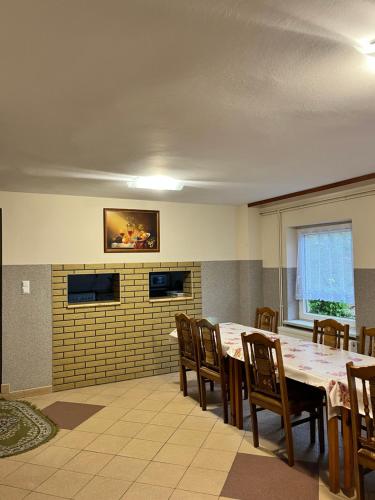a dining room with a table and wooden chairs at Gospodarstwo Agroturystyczne Na Górce pokój 8 in Myczkowce