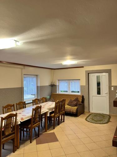 a living room with a table and chairs and a couch at Gospodarstwo Agroturystyczne Na Górce pokój 8 in Myczkowce