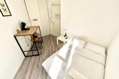 une chambre blanche avec un lit et une table dans l'établissement Pleasant apartment in a good location, à Montpellier