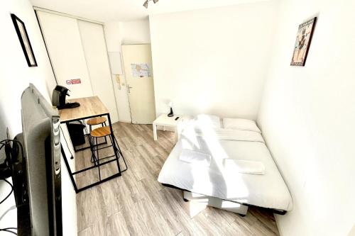 une petite pièce avec un lit et une table dans l'établissement Pleasant apartment in a good location, à Montpellier