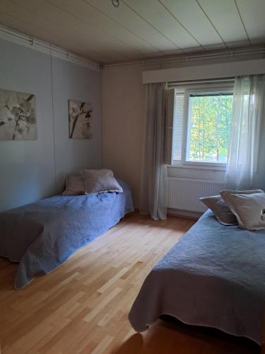 a bedroom with two beds and a window at Aalto A - A whole house with 5 bedrooms and a woodburning sauna in Oulu