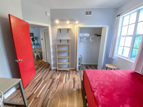 a bedroom with a red door and a red bed at Corporate Suite Midtown Wilmington in Wilmington