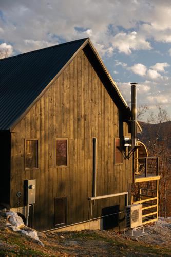 a large wooden barn with a staircase on the side at Arrow Head Cabin in Killington