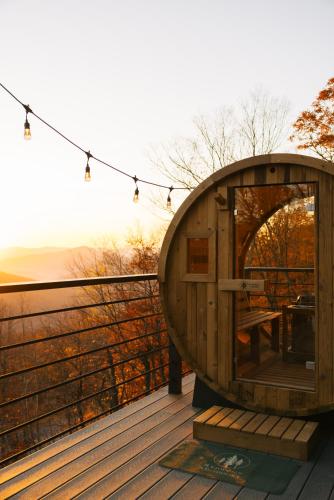 a wooden cabin on a deck with a table and lights at Arrow Head Cabin in Killington