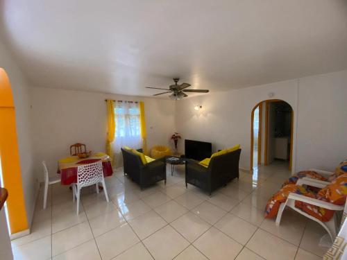 a living room with a couch and a table at Maison charmante à Baie-Mahault avec jardin clôturé in Baie-Mahault