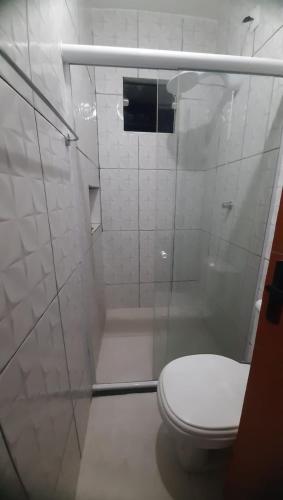 a white bathroom with a toilet and a shower at Casa Beira Mar - Boipeba in Ilha de Boipeba