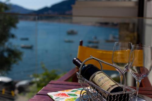 a bottle of wine and two glasses on a table at ACIKA apartments in Rafailovici