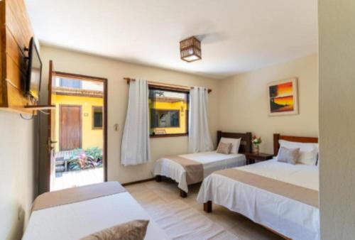 a hotel room with two beds and a window at Nova Pousada Don Pepe in Barra Grande