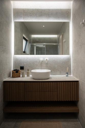 a bathroom with a sink and a large mirror at Villa Orama in Argos