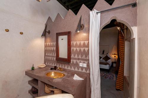 a bathroom with a sink and a mirror at Riad GUENAOUA Jacuzzi & Rooftop in Marrakesh