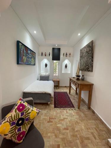 a bedroom with a bed and a desk in a room at Domaine des Mimosas in Essaouira