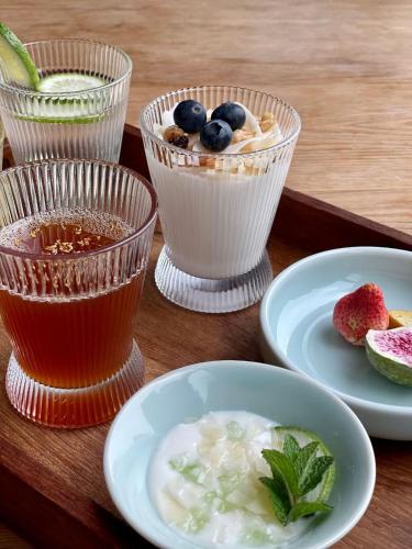 a table topped with plates of food and cups of drink at Dan’s Sea Guest House Hangzhou in Hangzhou