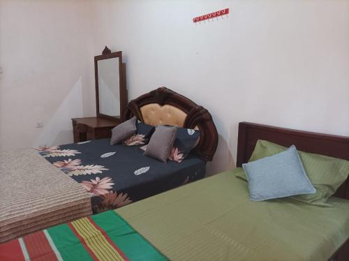 a bedroom with two beds and a mirror at The Danasa Heaven in Bandarawela