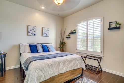 a bedroom with a bed with blue pillows and a window at Family-Friendly El Paso Home Hike, Shop and Explore in Santa Teresa