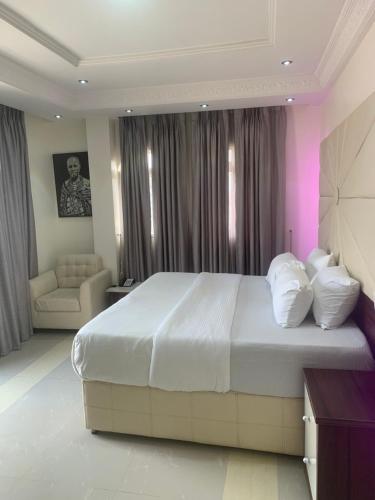 Un dormitorio con una gran cama blanca y un sofá. en Citi residence, en Lagos