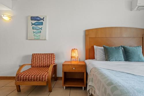 a bedroom with a bed and a chair and a lamp at Condado Lagoon by Otium in San Juan