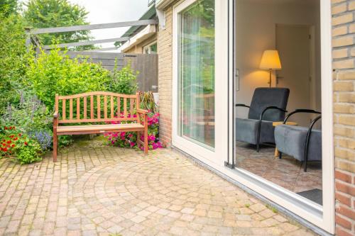 a wooden bench sitting on a patio next to a window at Wad Fijn in Sexbierum