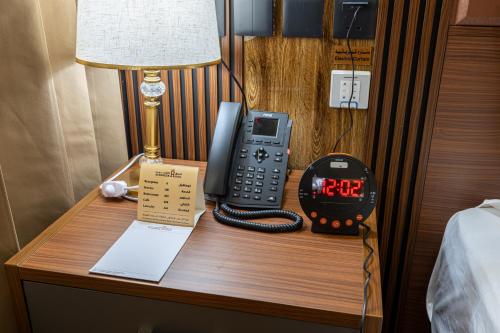 a desk with a phone and a clock on it at فندق الترحيب Atarheeb Hotel in Tabuk
