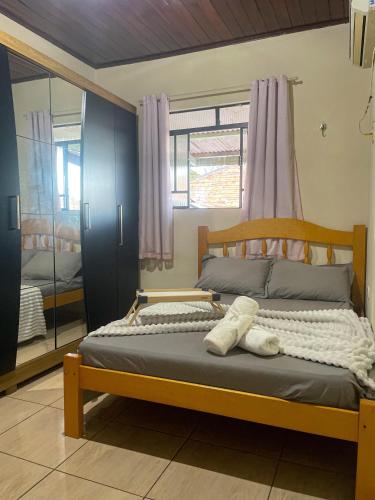 a bedroom with a bed and a window and a mirror at Conforto no Centro da Cidade in Alta Floresta